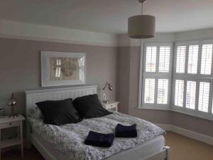 a bedroom with a bed with two pillows on it at Pretty coastal victorian cottage in Yarmouth IOW in Yarmouth