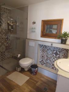 a bathroom with a toilet and a shower and a sink at Hill House with City view in Dezmir