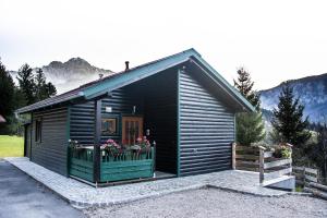 Ferienhütte Sonnreith في شبيتال أم بيرن: كابينة صغيرة مع شرفة عليها زهور