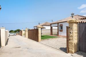 a row of houses in a street with a fence at Casita Torre de Meca 2 Sin piscina in Los Caños de Meca