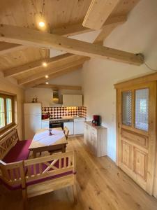 a room with a table and a kitchen with wooden ceilings at Ferienhütte Sonnreith in Spital am Pyhrn