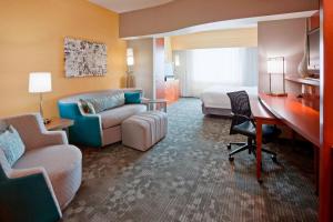 a hotel room with a bed and a desk at Courtyard Minneapolis Maple Grove Arbor Lakes in Maple Grove