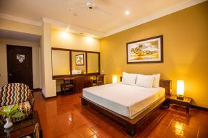 a bedroom with a bed and a desk in it at Club Palm Bay in Marawila