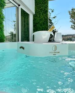 a bath tub in a swimming pool with water at One 360 Skyline Athens Penthouses in Athens