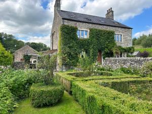 an ivy covered house with a garden in front of it at Large Country Farmhouse in Waddington