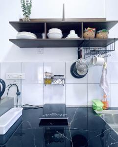 uma cozinha com paredes em azulejo preto e branco em LT Home em Sandakan