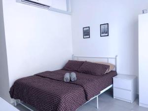 um quarto com uma cama com dois sapatos brancos em LT Home em Sandakan