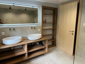 łazienka z 2 umywalkami i dużym lustrem w obiekcie Seppl Stoba w mieście Schruns