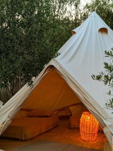 Tienda de campaña blanca y naranja con cama. en Garden Lake Camping, en Ksamil