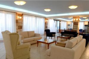 sala de estar con sofás, sillas y mesa en Koni Village Hotel, en Stalida