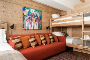 a bedroom with two bunk beds and a red couch at Chalet Le Favre in Chamonix-Mont-Blanc