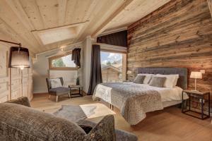 een slaapkamer met een bed en een houten muur bij Chalet Planards 2 in Chamonix-Mont-Blanc