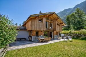 Casa de madera grande con terraza con sillas en Chalet Planards 2, en Chamonix-Mont-Blanc