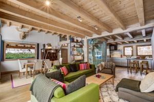 a living room with green couches and a table at Chalet Caleris in Chamonix-Mont-Blanc