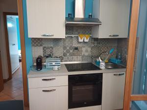 a kitchen with a sink and a stove top oven at Casa Vacanza Blue Sea in San Vito lo Capo