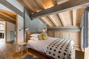 a bedroom with a large bed and wooden ceilings at Chalet Caleris in Chamonix