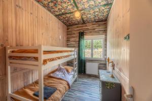 a bedroom with bunk beds in a wooden cabin at La Maison du Bois Brûlé 3 - Avec piscine partagée in Villaines-les-Rochers