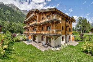 a large wooden house with a yard at Residence Le Green in Chamonix