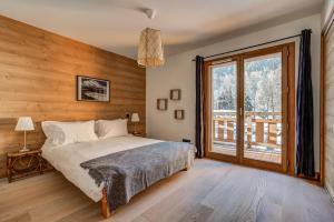 a bedroom with a bed and a large window at Residence Le Green in Chamonix