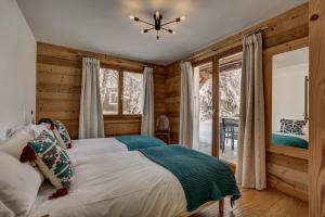 una camera con un letto e una grande finestra di Chalet Capricorne a Chamonix-Mont-Blanc
