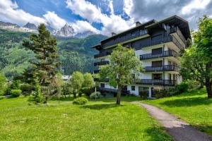 un edificio de apartamentos en las montañas con un árbol en Le Brevent 2 Apartment, en Chamonix-Mont-Blanc