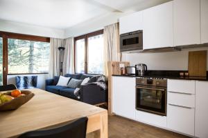 uma cozinha e sala de estar com uma mesa e um sofá em Le Brevent 2 Apartment em Chamonix-Mont-Blanc