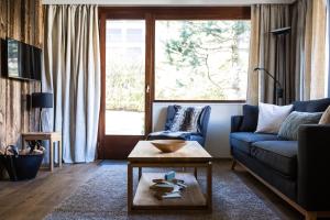 uma sala de estar com um sofá e uma mesa em Le Brevent 2 Apartment em Chamonix-Mont-Blanc