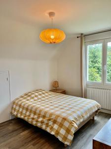 - une chambre avec un lit et une couverture en damier dans l'établissement Maison au calme à Dirinon, à Dirinon