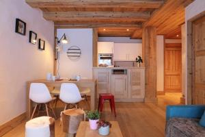 een keuken en een woonkamer met een tafel en stoelen bij Blaitiere 2 Apartment in Chamonix-Mont-Blanc