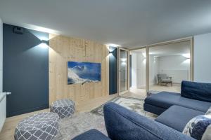 sala de estar con sofá azul y sillas en Chalet Breitalps, en Chamonix-Mont-Blanc