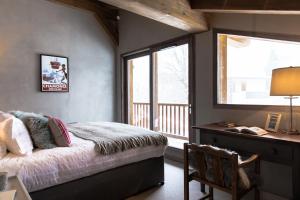 um quarto com uma cama, uma secretária e uma janela em Chalet Seren em Chamonix-Mont-Blanc