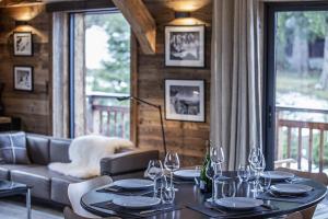 uma sala de jantar com uma mesa com copos de vinho em Chalet Black Wood em Chamonix-Mont-Blanc