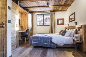 a bedroom with a bed and a desk and a window at Chalet Black Wood in Chamonix-Mont-Blanc