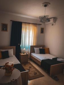 a bedroom with two beds and a window at Guest House Juald in Gjirokastër