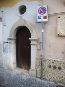 una señal de no estacionamiento junto a un edificio con puerta en Anfiteatro, en Formia