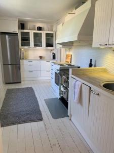 a kitchen with white cabinets and stainless steel appliances at In the heart of Old Rauma in Rauma
