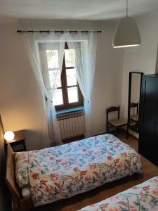 a bedroom with two beds and a window at Casabonsai in Fivizzano