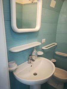 La salle de bains est pourvue d'un lavabo, d'un miroir et de toilettes. dans l'établissement Dimora La Chianca, à Marina Serra