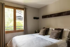 una camera con un letto bianco e una finestra di Villa Floria Apartment a Chamonix-Mont-Blanc
