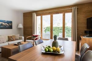 un soggiorno con tavolo e piatto di frutta di Villa Floria Apartment a Chamonix-Mont-Blanc