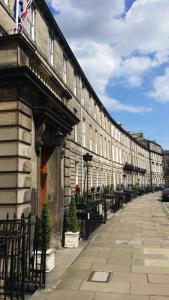 een groot gebouw met een hek naast een straat bij Royal Scots Club in Edinburgh