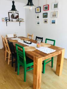 a wooden dining room table with green chairs at Casa bunicilor in Ucea de Jos +39 photos