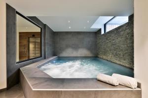 a hot tub in a room with a brick wall at Chalet Black Stone in Chamonix-Mont-Blanc +27 photos