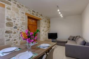 a living room with a wooden table with flowers on it at View Mare Maroulas in Maroulás