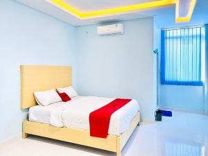 a bedroom with a bed with a red and white blanket at RedDoorz @ Jalan Lintas Pematangsiantar 