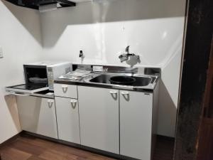 a kitchen with a sink and a microwave at 古民家クルンズ in Mino