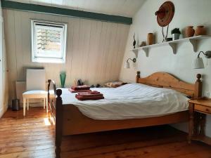 a bedroom with a wooden bed with towels on it at Gastenverblijf De Loft in Warns