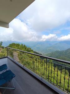 a balcony with two chairs and a view of mountains at Windmill Inn in Solan