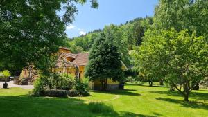 una casa in mezzo a un cortile con alberi di DOMAINE DES GRAVIERS a Plainfaing