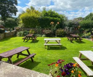 a group of picnic tables in the grass with flowers at Middle House in Askrigg